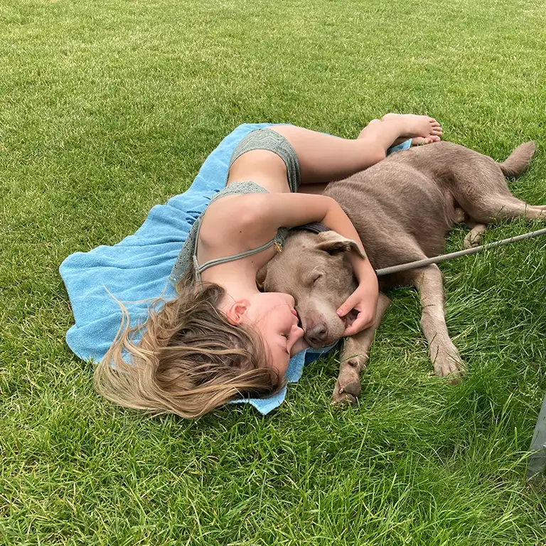 Mädchen kuschelt mit einem Hund